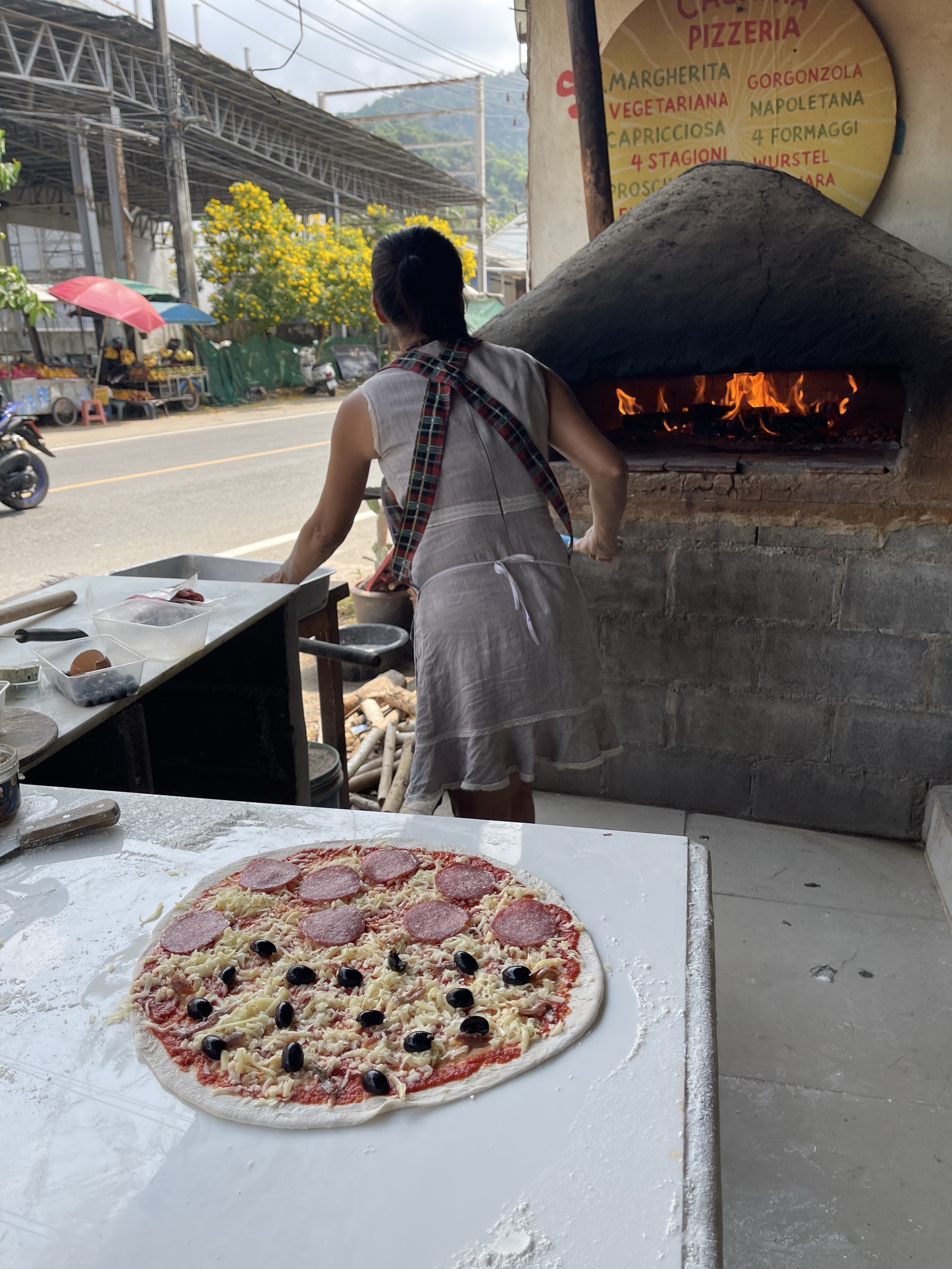 Casa Mia pizza being prepared beside the wood-fired oven