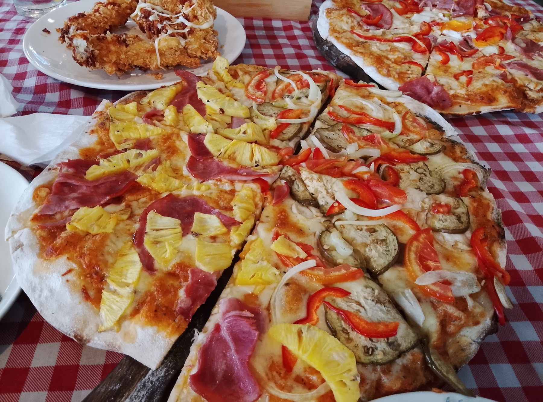 Casa Mia pizzas and an Italian sharing plate on a red checked table